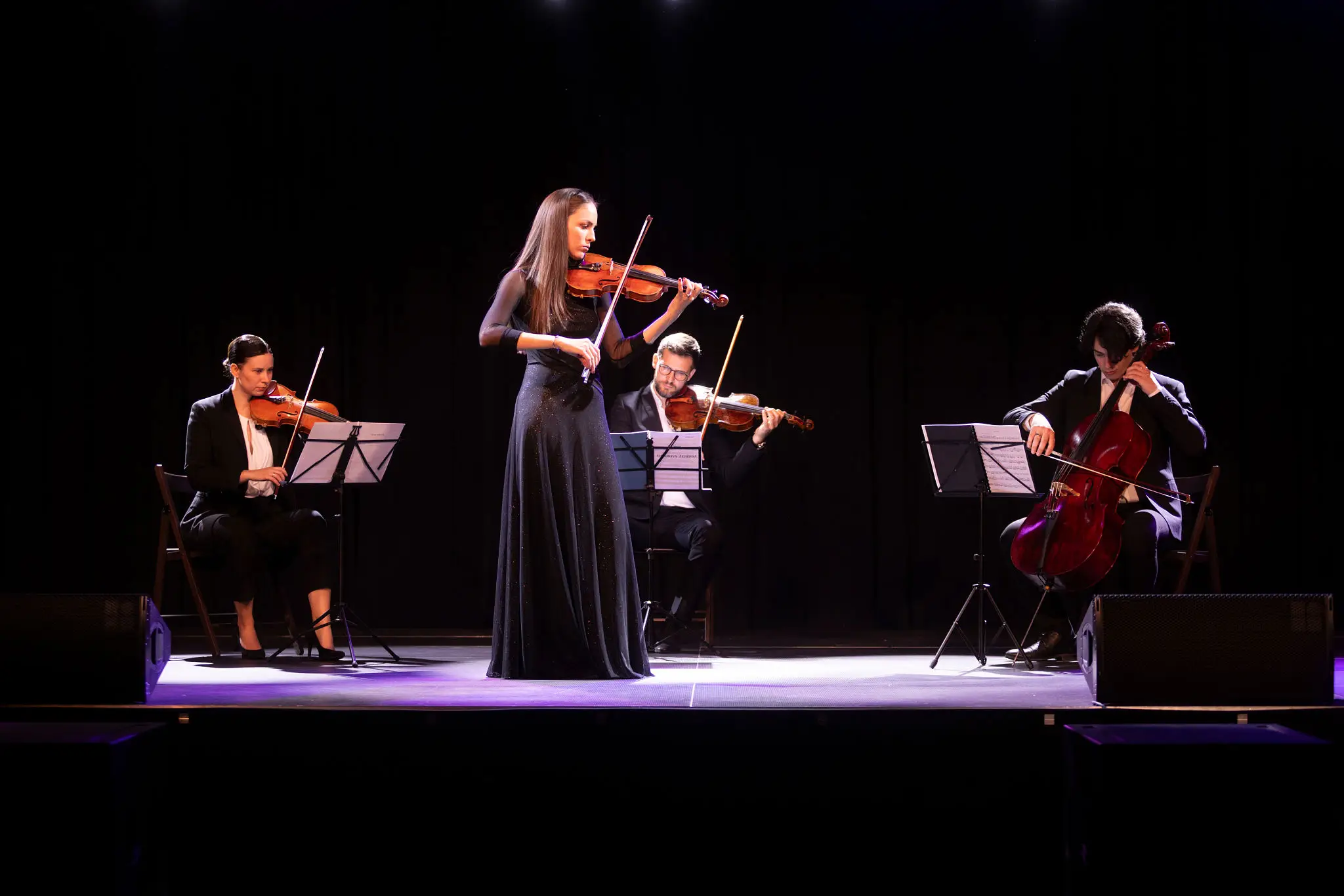 String quartet performing on stage in concert.